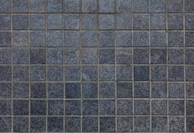 Küçük, koyu gri granit karoların yüzeyi. Kaldırımın ya da yürüyen yolların parçası, üst görünüm