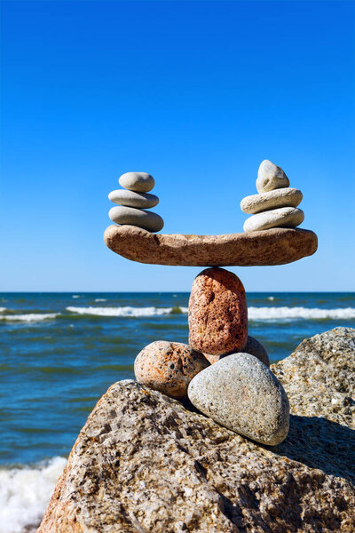 Concept of harmony and balance. Balance stones against the sea. Rock zen in the form of scales