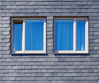 Evin duvarına siyah Silezya levhası ve iki pencere döşenmiş.