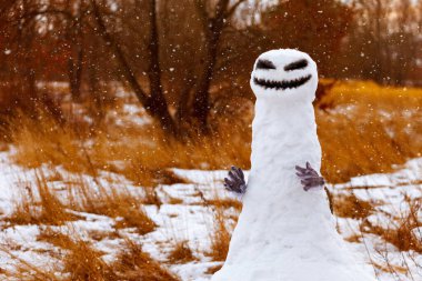scary snowman as a monster on a background of yellow grass. Halloween clipart