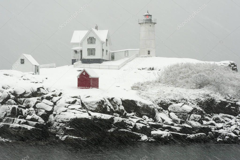 Nubble lighthouse, also known as Cape Neddick light, flashes its red light during a blizzard snowstorm in Maine, in New England.