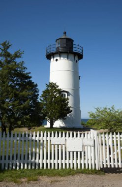 Massachusetts 'teki Marthas Vineyard Adası' nda yaz günü beyaz çitlerin önünde dökme demirden kulesi olan East Chop deniz feneri kulesi..