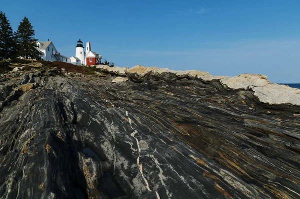 メイン州の中央海岸に位置するペマキッド ポイント灯台は 海から隆起した特殊な変成岩の上に位置している ニューイングランドへの観光客のためのお気に入りのアトラクションです ストック画像