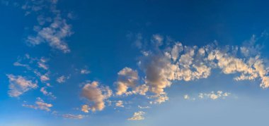 Turuncu pembe menekşe bulutların muhteşem görkemli görüntüsü mavi akşam gökyüzü. Detaylı çoklu katmanlar atmosferin düşük yüksek katmanlarıyla oynar. Ölen gün, yakıcı sıcak günbatımı. Panoramik, pankart için çok katmanlı bir dekorasyon. Kumsalda dinlenirken.