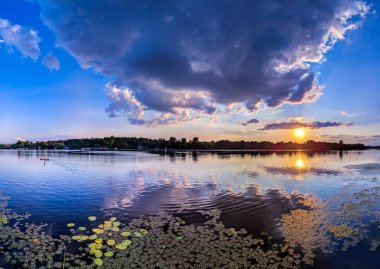 Gökyüzünde muhteşem bir günbatımı ve su nehrine yansıyan ılık ve serin tonlardan oluşan yumuşak pembe bulutlar tuvalde görüntüler canlandırıyor. Peri muamması derin, muhteşem, karanlık, destansı gökyüzü. Dramatik akşam ışığı ve ateşli turuncu menekşe gün batımı. Mavi arkaplanda sarı ateş.