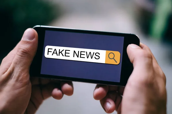Haberler SEO kavramı: sahte haberler yakın akıllı telefon ekranında arama çubuğunda görüntülenir