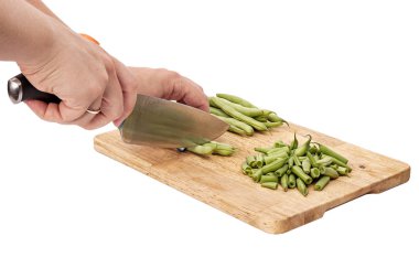 Bir tabloda bir kesme tahtası üzerinde taze fasulye dilimleme, beyaz arka plan izole