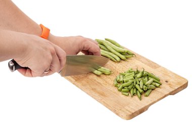 Bir tabloda bir kesme tahtası üzerinde taze fasulye dilimleme, beyaz arka plan izole