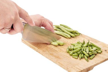 Bir tabloda bir kesme tahtası üzerinde taze fasulye dilimleme, beyaz arka plan izole