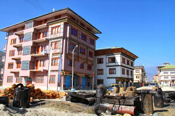 木製の窓枠とブータンのパロで道路の交差点に熱いアスファルト タンク建設現場彫りで飾られた伝統的なブータン風建物 — ストック写真