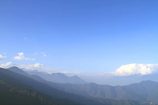 朝の山は落葉性の針葉樹林で覆われている山の峰の層で風景します ティンプーから Punaka ブータンへの道のドチュラ峠からの眺め — ストック写真