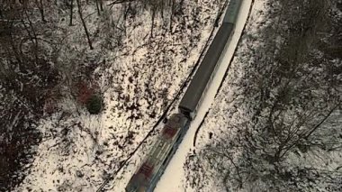 Poprad Parkı 'ndaki Poprad Nehri' nin üzerinden geçen yolcu treninin hava görüntüsü bulutlu, kış günü.