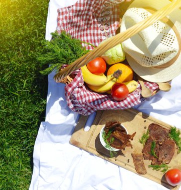 Çimenlerin üzerinde parkta piknik: sağlıklı gıda ve aksesuarları, üstten görünüm