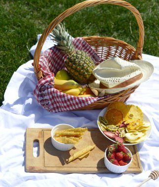 Çimenlerin üzerinde parkta piknik: sağlıklı gıda ve aksesuarları, üstten görünüm