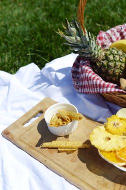 Çimenlerin üzerinde parkta piknik: sağlıklı gıda ve aksesuarları, üstten görünüm
