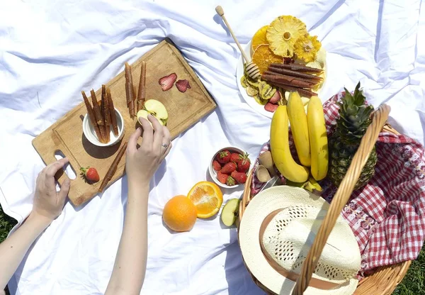 Çimenlerin üzerinde parkta piknik: sağlıklı gıda ve aksesuarları, üstten görünüm