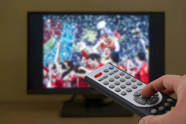 Sport TV fjärrkontroll i handen, zappande Stockfoto