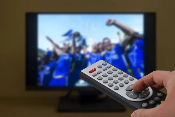 Sport TV fjärrkontroll i handen, zappande Stockbild