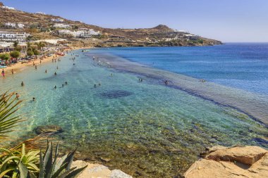 Paradise beach, Mykonos, Yunanistan'ın Kalamopodi. Kristal berraklığında su ve mavi gökyüzü güneşli. Mykonos kesinlikle en ünlü plaj cennettir: ince kum ve zümrüt yeşil su.
