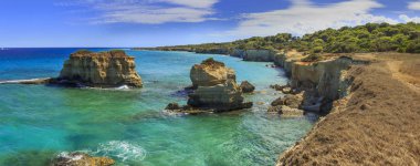 Apulia 'nın en güzel kıyıları: Torre Sant' Andrea, Otranto, İtalya (Lecce). Salento 'nun tipik kıyı şeridi: Punticeddha plajı manzarası. Kayalıklı deniz manzarası, kayalık kemer ve deniz yığınları. 