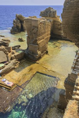 İtalya'nın en güzel plajı: Salento sahili, Santa Cesarea Terme (Apulia). Santa Cesarea Terme'nin kayalık plajı. Deniz kenarında, tüm kıyı boyunca derin sularla dolu..