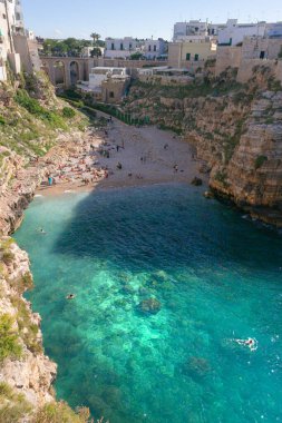 Polignano a Mare: İtalya 'daki Cala Monachile Plajı (Apulia). Polignano 'nun merkezinde yer alır ve tarihi merkezden birkaç adım uzaktadır..
