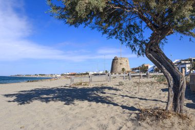 Torre Mozza Sahili, Salento, Apulia (İtalya). Harap olmuş gözetleme kulesi, kristal berrak suyla çevrelenmiş ince kumlu Torre Mozza 'nın uzun plajına bakıyor..