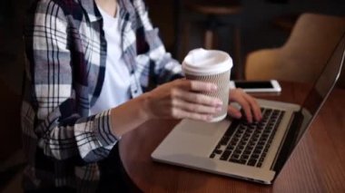 Güzel kız kahve içer ve bilgisayarda çalışır