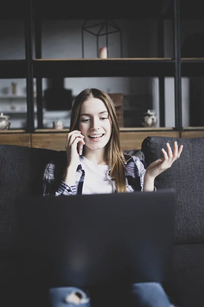 Glad ung vacker kvinna med laptop och prata på phon — Stockfoto