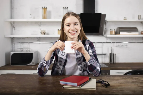 Menina feliz bebe café e lê um livro pela manhã — Fotografia de Stock