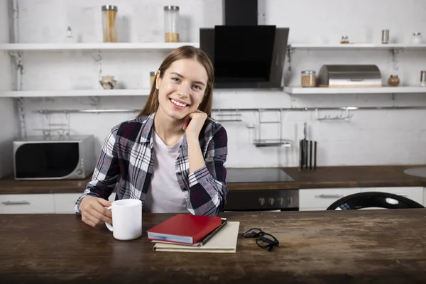 Menina feliz bebe café e lê um livro pela manhã — Fotografia de Stock