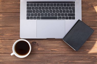 Eski ahşap masada kahve ve dizüstü bilgisayar ile açık dizüstü kapatın