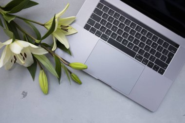 Eski ahşap masa üzerinde çiçek ile açık dizüstü kapatın. Düz yatıyordu st