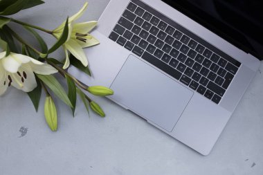 Eski ahşap masa üzerinde çiçek ile açık dizüstü kapatın. Düz yatıyordu st