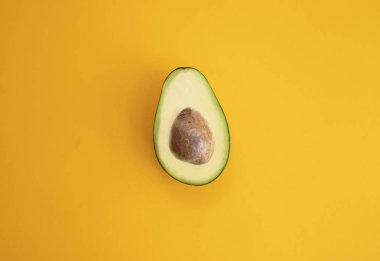 Parlak sarı arka plan üst vie olgun dilimlenmiş avokado kadar yakın