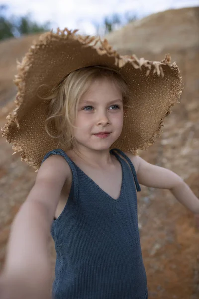 Niña linda en ropa elegante sobre un fondo de rocas. Su — Foto de Stock