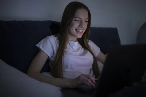 Женщина, использующая ноутбук ночью — стоковое фото