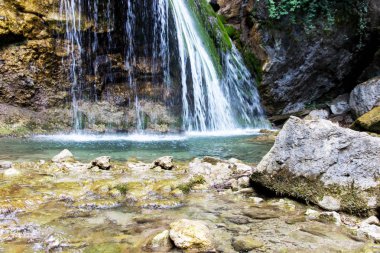 Şelale Jur-Jur yaz, yeşil yosun ve su, Kırım, Rusya Federasyonu. Ormanın içinde büyük bir taş üzerinden düşen su beyaz akarsu