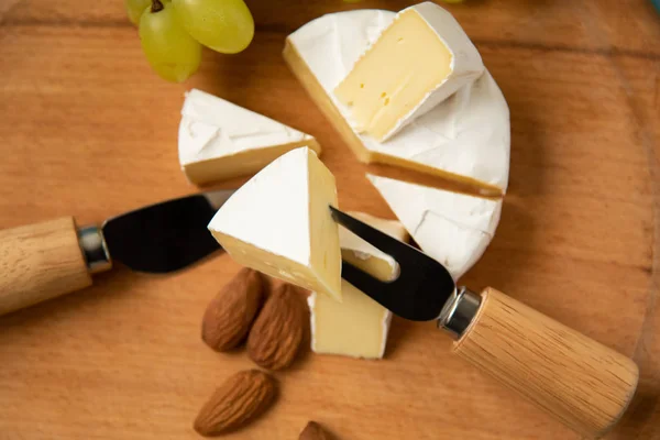 Rodajas de queso camembert con frambuesas y frutos secos —  Fotos de Stock