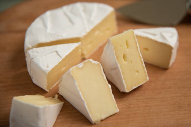 dilim bir kesme tahtası üzerinde camembert peyniri