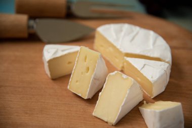 dilim bir kesme tahtası üzerinde camembert peyniri