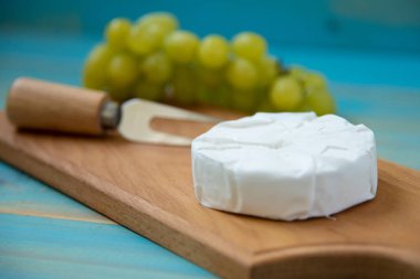 camembert peyniri ve üzüm için bir çatal ile peynir