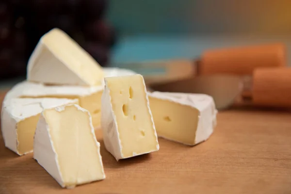 Сыр камамбер или бри на синем деревянном фоне — стоковое фото
