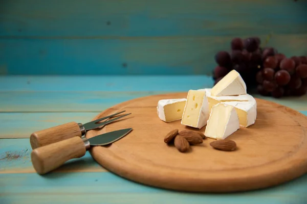 Sýr camembert nebo brie na modré dřevěné pozadí — Stock fotografie