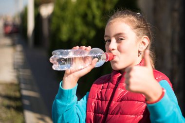 Güzel kız içme su içinde açık koşu yaptıktan sonra