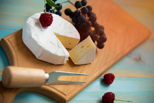 Сыр камамбер с малиной и виноградом на — стоковое фото