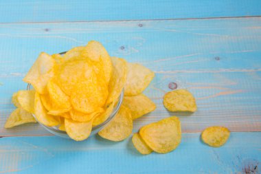 Patates cipsi kase mavi ahşap arka plan üzerinde