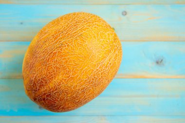 Eski mavi ahşap masa üzerinde taze kavunlar