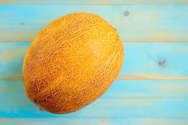 Eski mavi ahşap masa üzerinde taze kavunlar