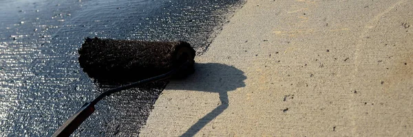 Roofer worker painting black coal tar or bitumen — Stock Photo, Image